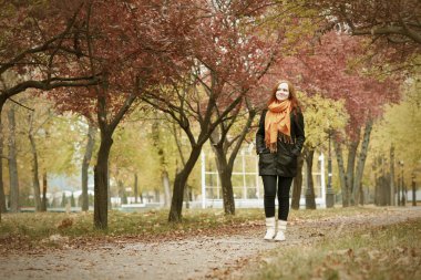 Kızıl saçlı kız yürüyüş yolu şehir Park, sonbahar sezon