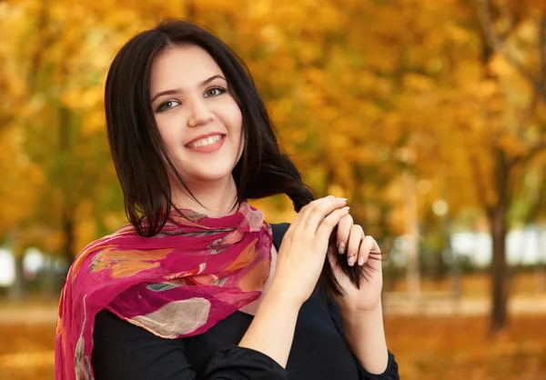 Krásná dívka v černých šatech a červeným šátkem v žluté městském parku, podzim — Stock fotografie