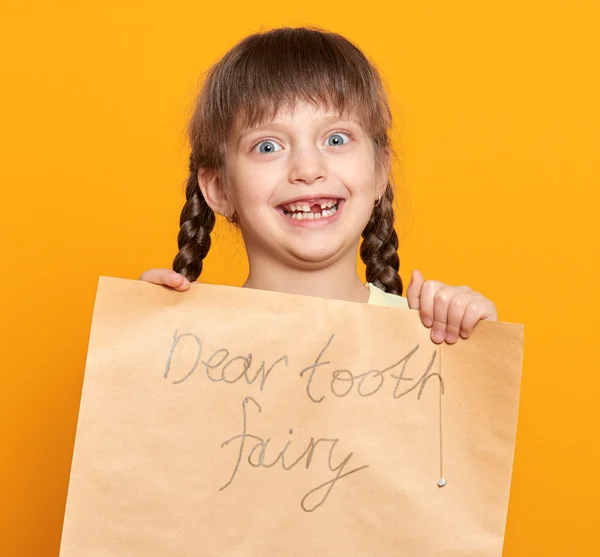 Verloren tand meisje portret, studio schieten op gele achtergrond — Stockfoto