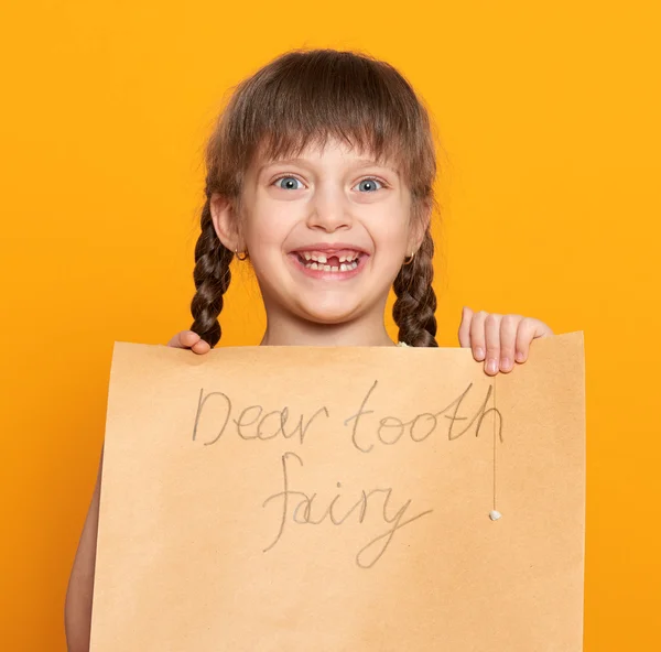 Retrato de menina dente perdido, estúdio atirar no fundo amarelo — Fotografia de Stock