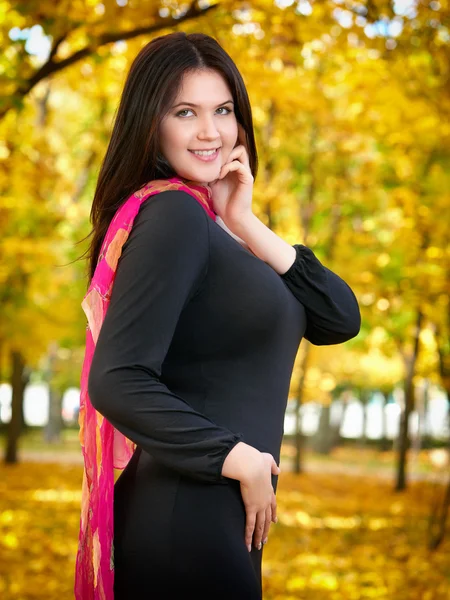 Beautiful woman in black dress in yellow city park, fall season — Stock Photo, Image