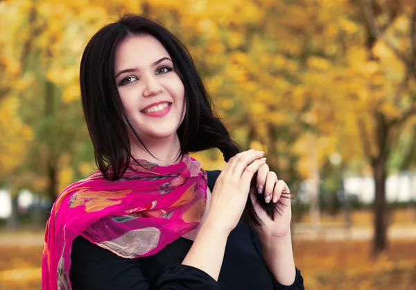 Krásná dívka v černých šatech a červeným šátkem v žluté městském parku, podzim — Stock fotografie