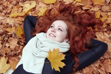 Kızıl saçlı kız yatan şehir park, Sonbahar sezonu bırakır.