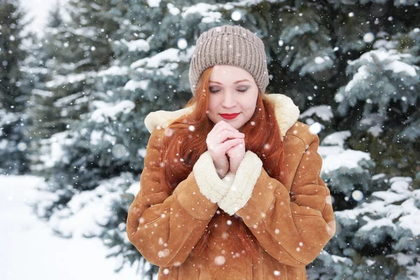 Jovem mulher aquece as mãos no inverno — Fotografia de Stock