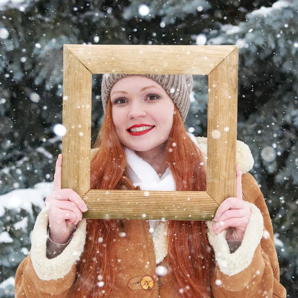 女人在木制相框在冬季室外肖像。下雪的天气，在杉木树公园. — 图库照片