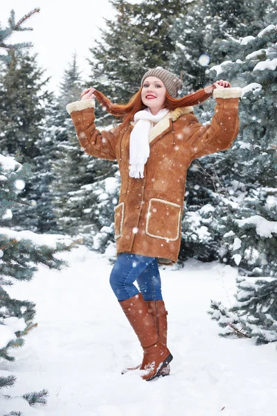 Muchacha mostrar pelo en el parque de invierno en el día. Abeto con nieve. Pelirroja mujer longitud completa . — Foto de Stock