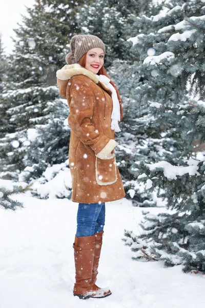 Menina posando no parque de inverno durante o dia. Abeto com neve. Ruiva mulher comprimento total . — Fotografia de Stock