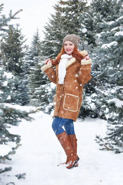 Chica posando en el parque de invierno en el día. Abeto con nieve. Pelirroja mujer longitud completa . — Foto de Stock