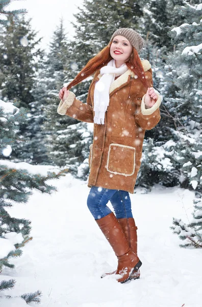 女孩在冬季公园在天。与雪冷杉树。红发女人全长. — 图库照片
