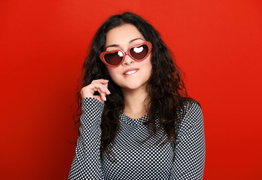 beautiful girl glamour portrait on red in heart shape sunglasses, long curly hair clipart