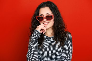 güzel kız glamour portre kırmızı kalp şekli güneş gözlüklü, uzun kıvırcık saç