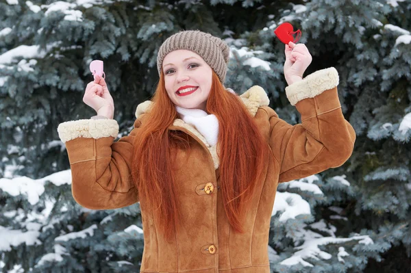 젊은 여자 레드 심장 장난감 포즈. 겨울 시즌입니다. 공원에서 야외 초상화입니다. 눈 덮인 날씨입니다. 발렌타인 개념. — 스톡 사진