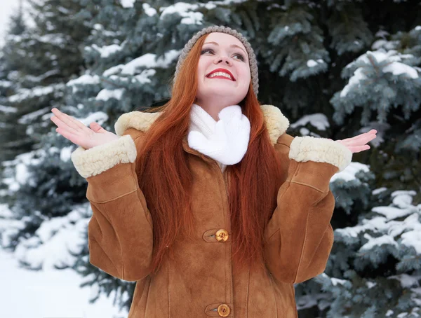 Happy young woman at winter and snowy fir trees — Stock Photo, Image