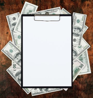 Pano sayfasında boş kağıt para dolar ve eski ahşap arka plan ortasına yerleştirilir. İş planı ve diğer bilgi kavramı.