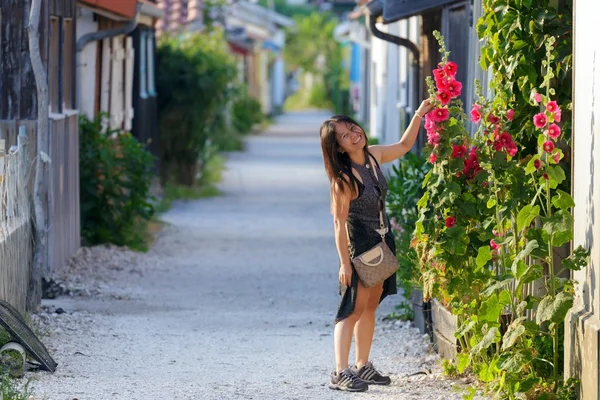 Frau zeigt Stockrosenblüten — Stockfoto