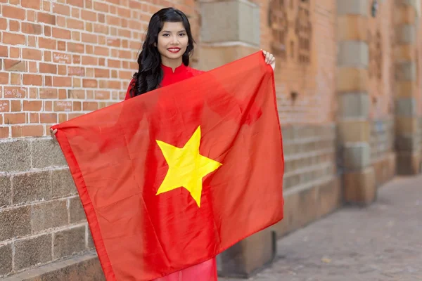 Pretty young Vietnamese woman holding a flag — Stock Photo, Image