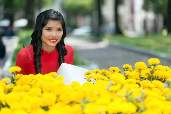 Attraktive Vietnamesin mit gelben Blüten — Stockfoto