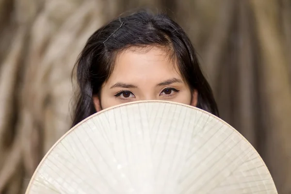 Mujer misteriosa cubriendo media cara con ventilador — Foto de Stock