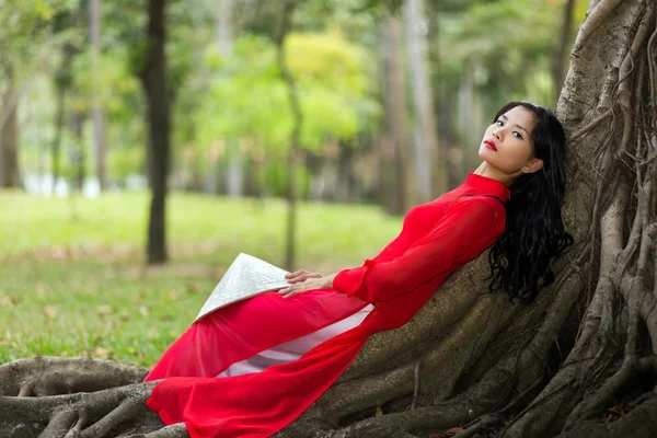 Pretty Vietnamese lady relaxing on tree roots — Stock Photo, Image