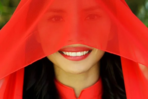 Glückliche junge Frau mit rotem Schal, der ihr Gesicht verhüllt — Stockfoto