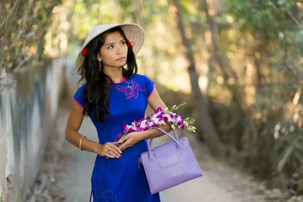 Pretty young Vietnamese woman carrying flowers — Stock Photo, Image