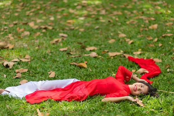 Feliz ásia mulher deitado para baixo no pastagem — Fotografia de Stock