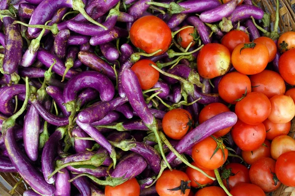Berenjenas frescas y tomates en el mercado —  Fotos de Stock