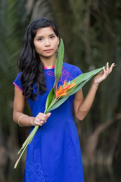 Jeune femme en bleu Ao Dai tenant des fleurs — Photo