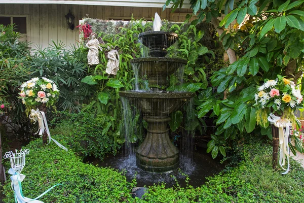 Brunnen mehrstufig und Blumenstrauß im Garten — Stockfoto