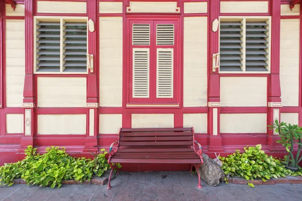 Röd stol framför vintage träbyggnad — Stockfoto