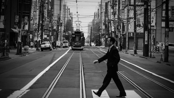 Man cross street while tram is riding — Stock Photo, Image
