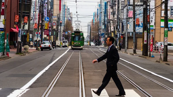 Man cross street terwijl tram rijden — Stockfoto
