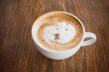 Ahşap masada kapuçino kahvesi.