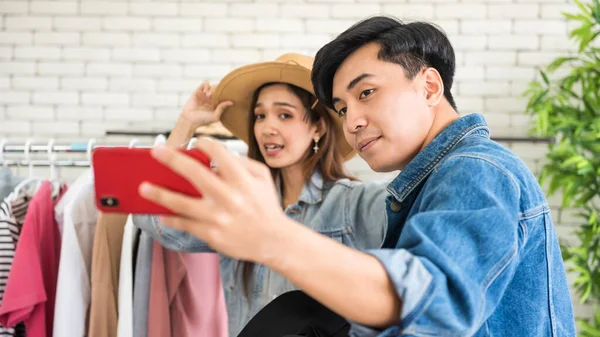 Couple fashion blogger or Stylist influencer man and woman live to sell hat and cloth in studio. Opinion leader trend on online blog channel. New normal of seller. live video streaming by smartphone.
