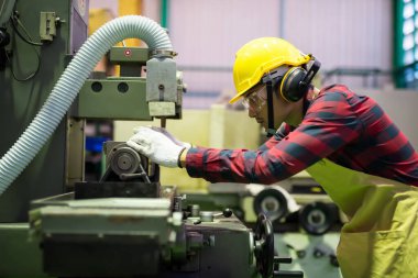 Fabrikadaki eski el değirmeni demir fabrikasında çalışan yetenekli tamirci. Kask, eldiven ve ekose gömlekli teknisyen metal nesneyi değiştirir..