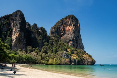 Railay Sahili 'ndeki insanlar karst dağı manzaralı, kristal turkuaz deniz ve Tayland, Krabi' de mavi gökyüzü. Yaz tatili için Güneydoğu Asya 'ya tatile gitti. Meşhur seyahat yeri.