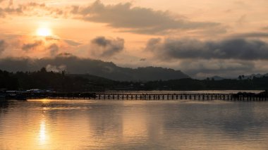 Sangkhlaburi 'de, Kanchanaburi' de, Tayland 'da, güneş doğarken ve sisli bir ahşap köprü. Tayland 'da ünlü seyahat merkezi ya da tatilci.