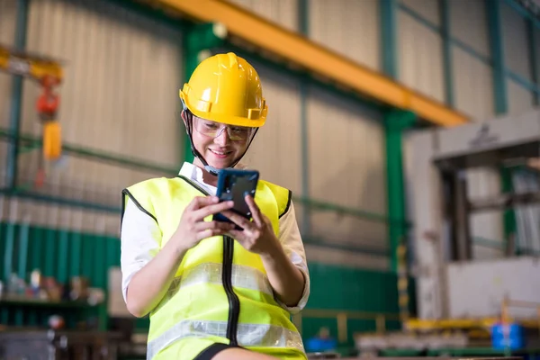 亚洲女工们在午休期间 用智能手机在仓库里玩社交媒体 发短信 努力工作后 微笑的女人放松一下 免版税图库图片