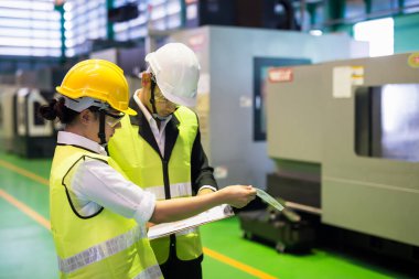 Factory inspector and auditor manager discuss inspection by checking mock up model on paper for internal audit of CNC lathe milling machine. Quality assurance (QA) for manufacturing industry.