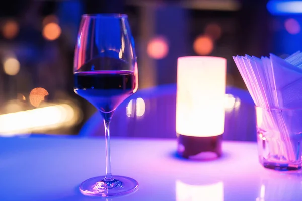 Szklanka Czerwonego Wina Stole Baru Rozmytym Kolorowym Światłem Bokeh Nocy — Zdjęcie stockowe