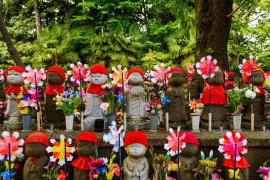 Zojoji Tapınağı, Tokyo, Japonya 'da doğmamış çocuklar için çocuk yel değirmeni ve çiçek süslemesi olan Jizo anıtları veya heykelleri.