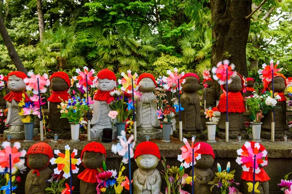 Zojoji Tapınağı, Tokyo, Japonya 'da doğmamış çocuklar için çocuk yel değirmeni ve çiçek süslemesi olan Jizo anıtları veya heykelleri.
