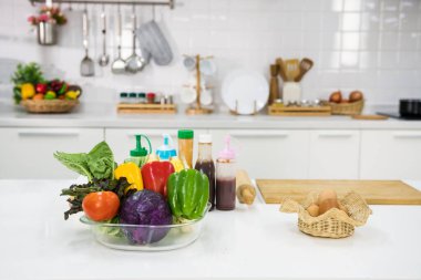 Mutfakta salata ve sandviç yapmak için yemek malzemesi. Domates, marul, kırmızı ve yeşil biber, lahana, masada yumurta.