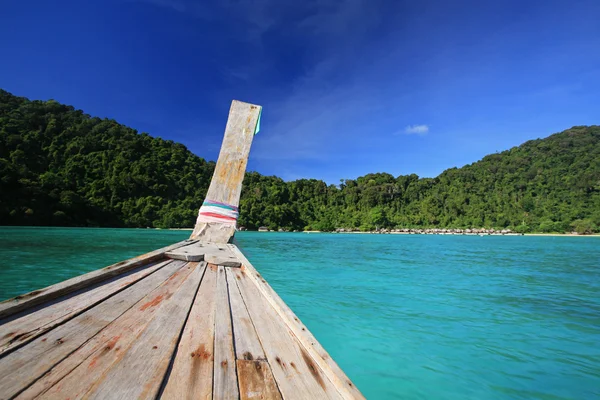 Holzboot mit langem Schwanz segelt auf kristallklarem Meer — Stockfoto