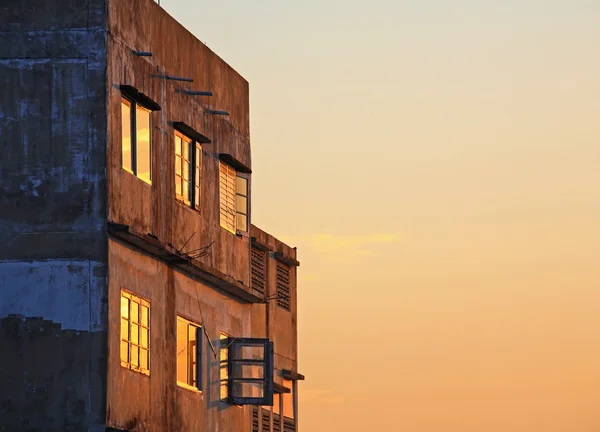 Velho prédio de apartamentos com céu nascer do sol — Fotografia de Stock