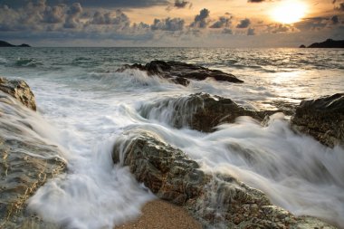 Dalga hareket, Phuket ile taş sahilde günbatımı