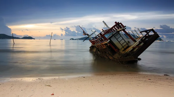 Destruição na praia ao amanhecer — Fotografia de Stock