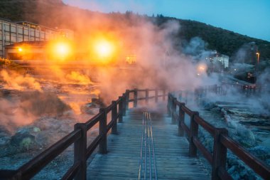 Dağın yanındaki patikada yürüyorum. Jigoku Cehennem Vadisi 'ni sülfür gazı kaplıcalarıyla ve geceleri Japonya' nın Nagasaki şehrinin ışıklarıyla aydınlatan otelle aydınlat. Sıcak su, gaz ve buhar topraktan fışkırıyor..