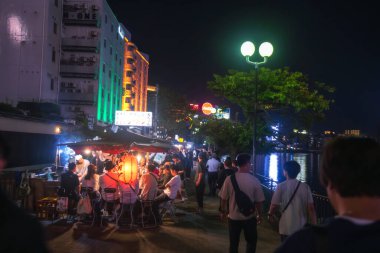 Japon ve turistler, Japonya 'nın Nakasu Adası' ndaki ünlü yemek tezgahlarında veya yatai 'de akşam yemeğinin keyfini çıkarıyorlar.