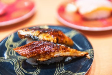 Unagi Eel suşisi Japon restoranında siyah boyalı porselen tabakta